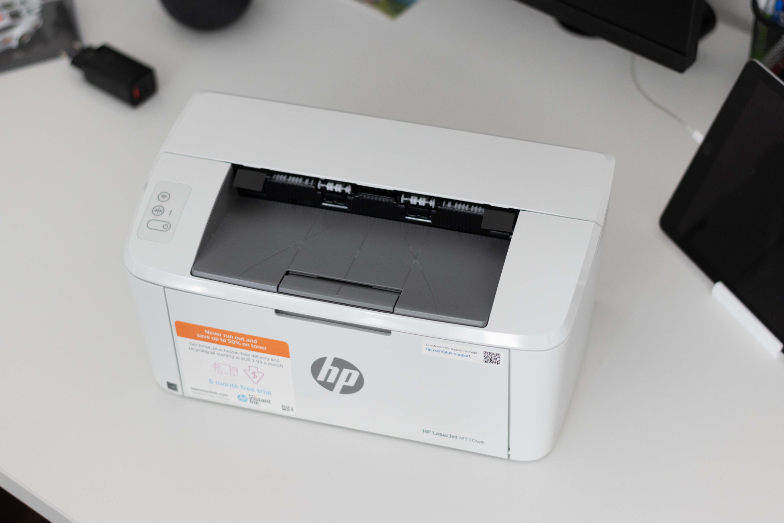 Tiskalnik HP LaserJet M110we od zgoraj na pisarniški mizi.