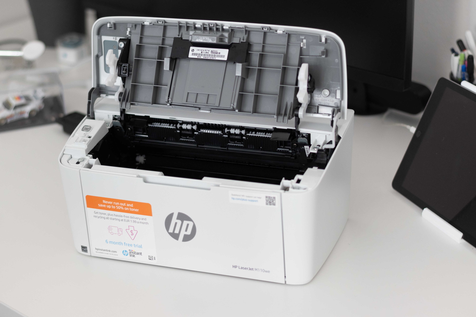 Tiskalnik HP LaserJet M110we z pregibno zgornjo stranjo za vstavljanje tonerja. 